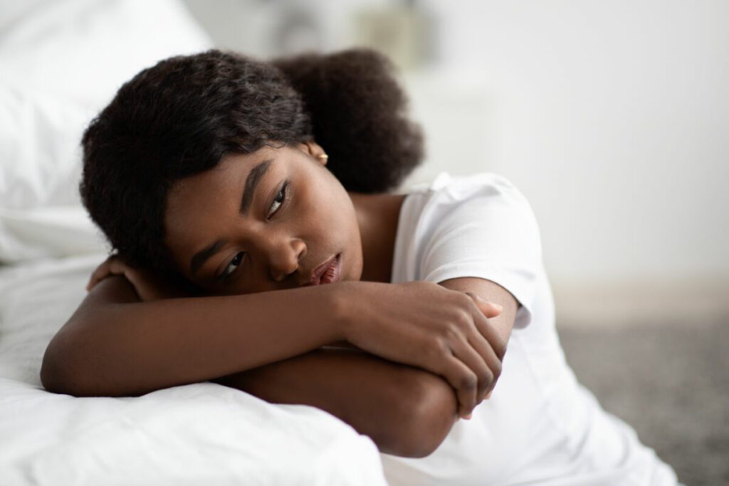 depressed african american woman sitting by bed at 2022 12 16 08 07 04 utc