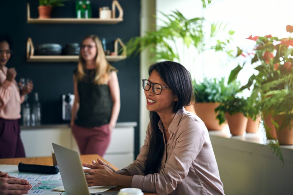 smiling asian businesswoman working at a table in 2022 02 02 03 47 55 utc